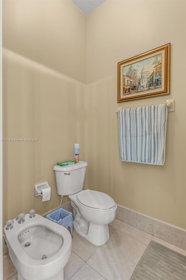 bathroom featuring tile patterned floors, toilet, and a bidet