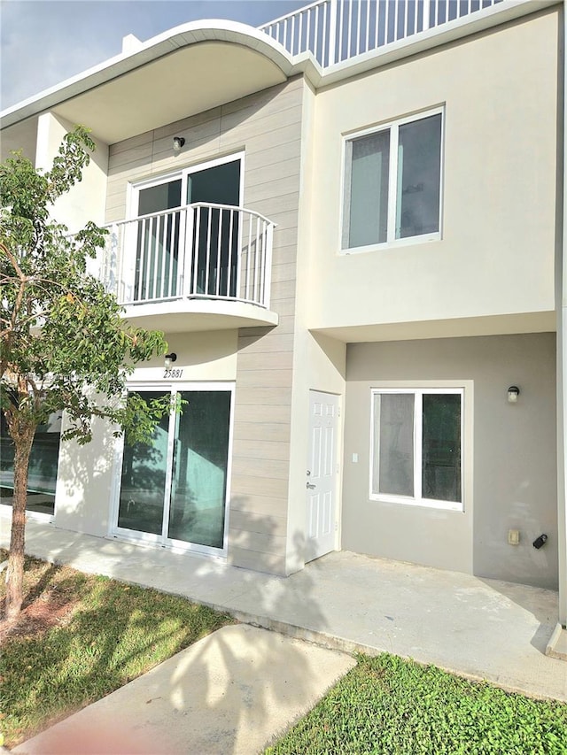 back of house with a balcony and a patio area