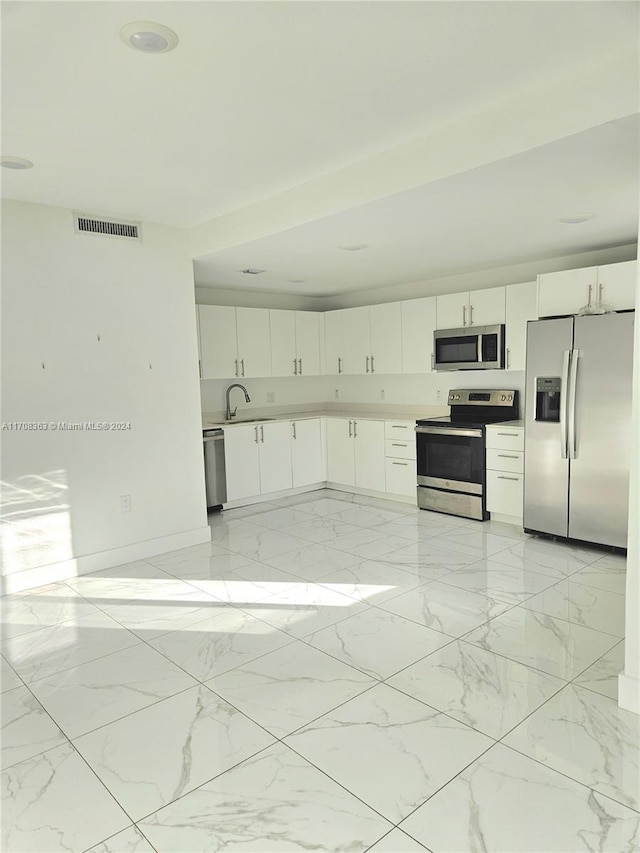 kitchen featuring white cabinets, stainless steel appliances, and sink