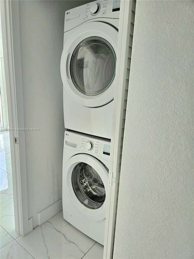 clothes washing area featuring stacked washing maching and dryer