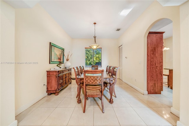 2913 SW 13th St, Miami, FL 33145 - dining area with arched walkways, light tile patterned flooring, and baseboards