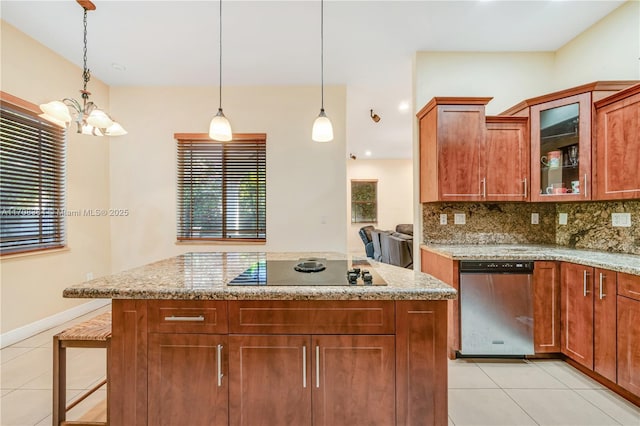 kitchen with decorative light fixtures, light stone counters, decorative backsplash, and dishwasher