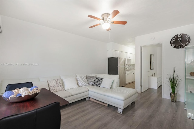 living room with ceiling fan, sink, and dark wood-type flooring