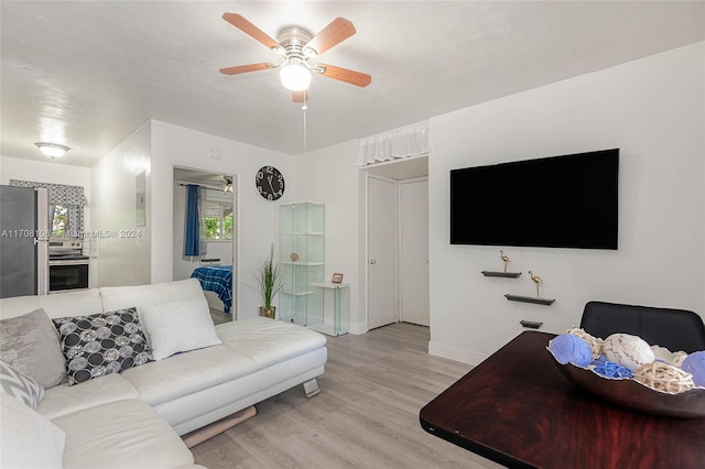 living room featuring light wood-type flooring and ceiling fan