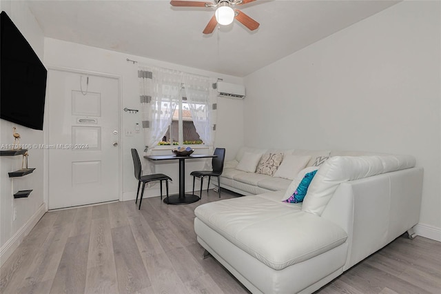 living room featuring ceiling fan, an AC wall unit, and light hardwood / wood-style flooring