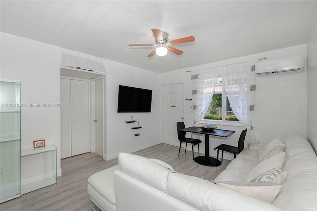 living room with an AC wall unit, ceiling fan, and light wood-type flooring