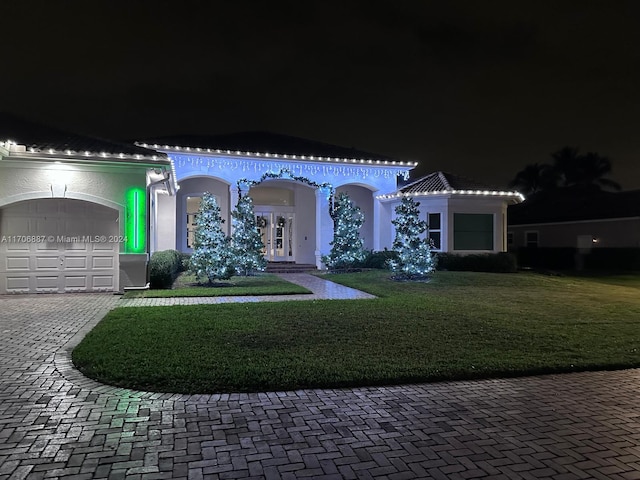 mediterranean / spanish-style house featuring a lawn and a garage