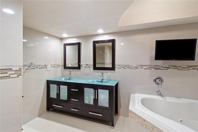 bathroom featuring tile patterned floors, tiled bath, and vanity