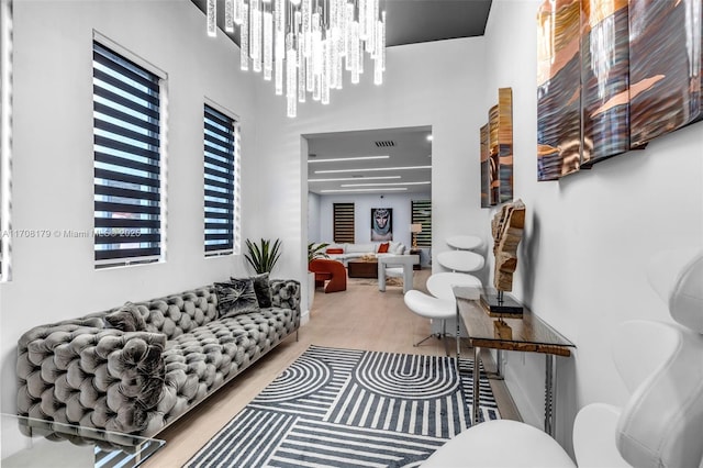 living room featuring visible vents, a chandelier, and wood finished floors