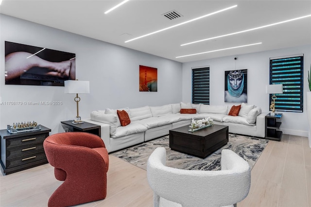 living area featuring visible vents and wood finished floors