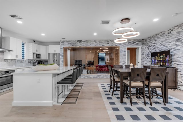 kitchen featuring a breakfast bar, hanging light fixtures, appliances with stainless steel finishes, a notable chandelier, and white cabinets