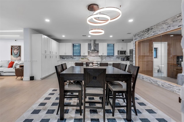 dining area with light wood-type flooring, visible vents, and recessed lighting