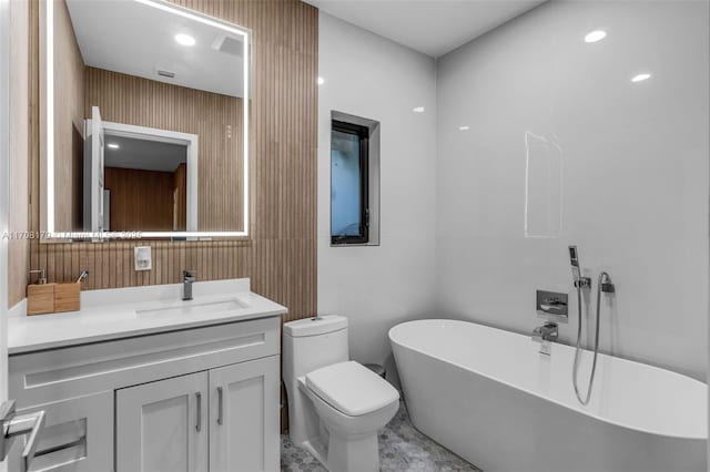 bathroom with a soaking tub, vanity, and toilet