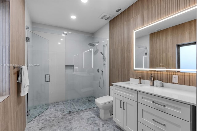 bathroom with toilet, a shower stall, visible vents, and vanity