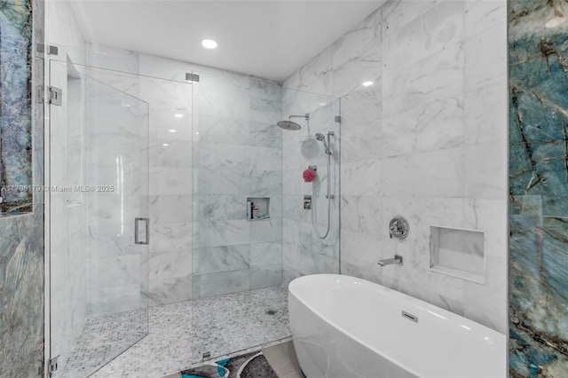 bathroom featuring tile walls, a freestanding bath, and a shower stall