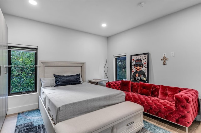 bedroom featuring baseboards, wood finished floors, and recessed lighting