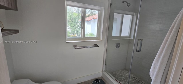 bathroom with toilet and a shower with shower door