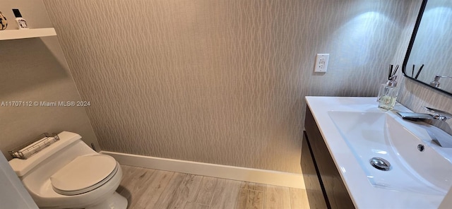 bathroom with hardwood / wood-style floors, vanity, and toilet