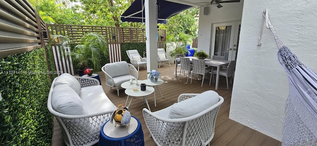 wooden deck with an outdoor living space and ceiling fan