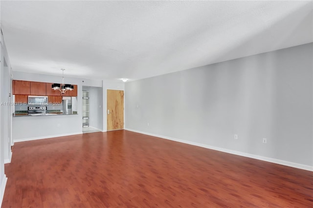 unfurnished living room with hardwood / wood-style flooring and an inviting chandelier