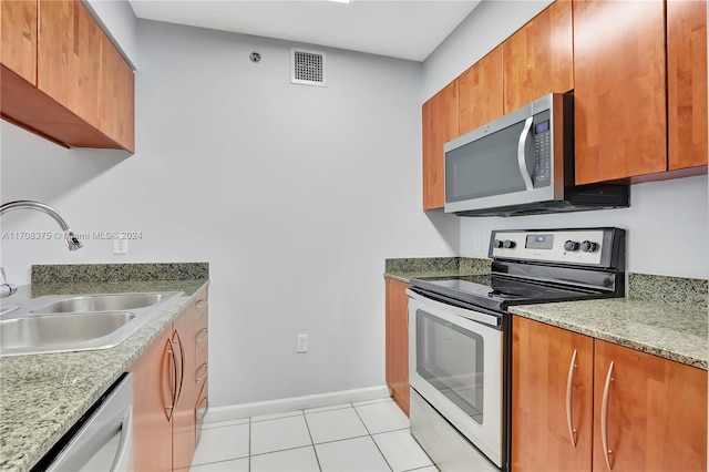 kitchen with appliances with stainless steel finishes, light tile patterned floors, and sink