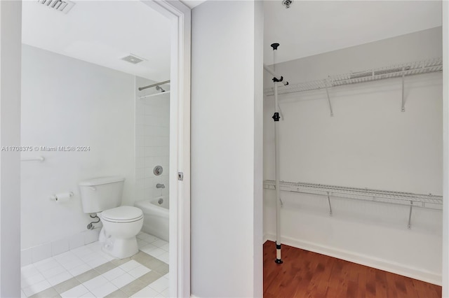 bathroom featuring shower / bath combination, toilet, and wood-type flooring