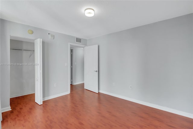 unfurnished bedroom with hardwood / wood-style floors and a closet