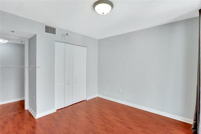 unfurnished bedroom featuring a closet and hardwood / wood-style flooring