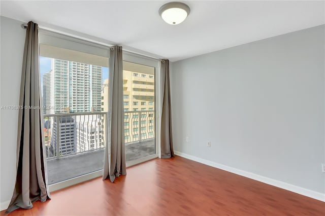 unfurnished room with hardwood / wood-style flooring