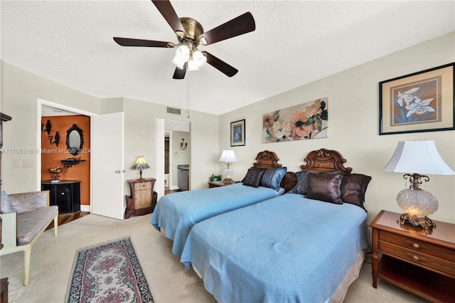 bedroom with ceiling fan, a textured ceiling, and light carpet