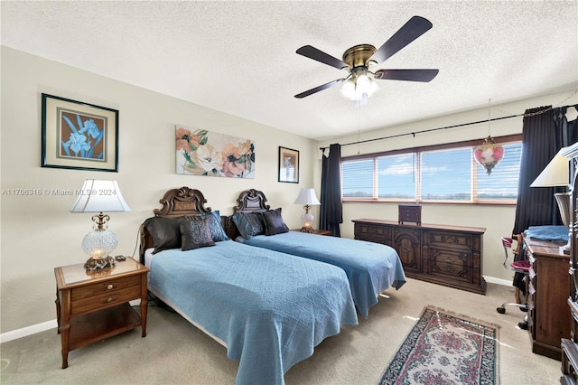 bedroom featuring ceiling fan, light colored carpet, and a textured ceiling