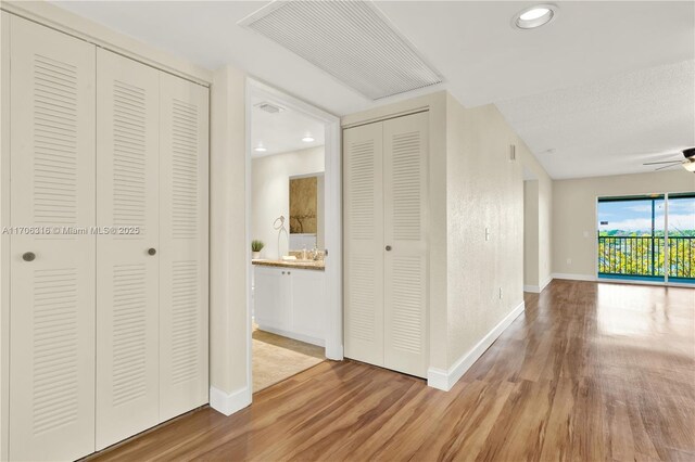 dining room with ceiling fan with notable chandelier, wood-type flooring, and a textured ceiling