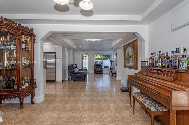 tiled foyer entrance with bar area and a tray ceiling