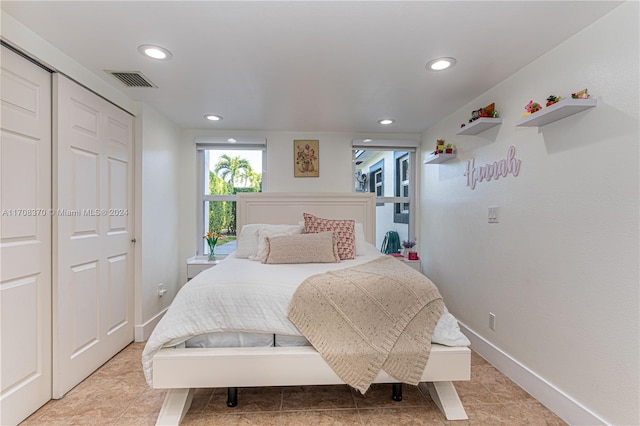 bedroom with tile patterned flooring and a closet