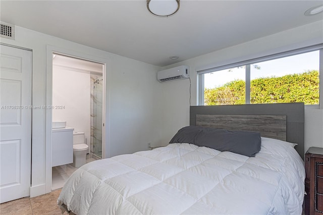 tiled bedroom with a wall unit AC and ensuite bath