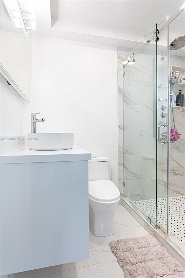 bathroom with vanity, toilet, and a shower with door