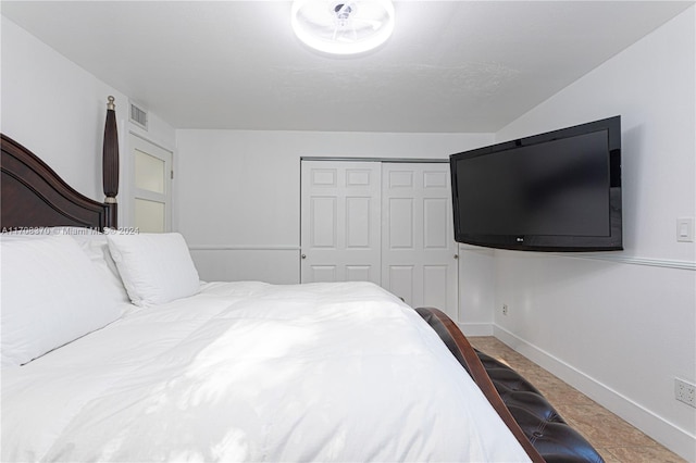 bedroom with tile patterned flooring and a closet