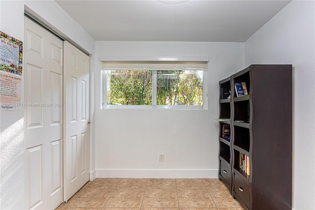 unfurnished bedroom with light tile patterned floors and a closet