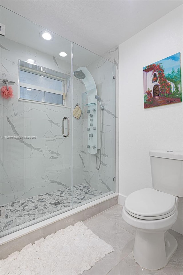 bathroom with toilet and a shower with shower door