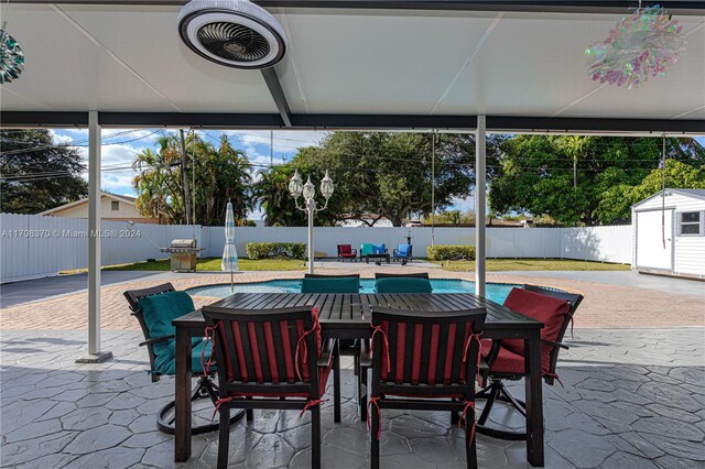 view of patio / terrace with a fenced in pool and a shed