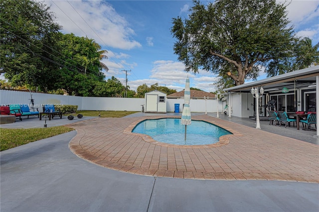 view of swimming pool featuring an outdoor hangout area, a patio, and a shed