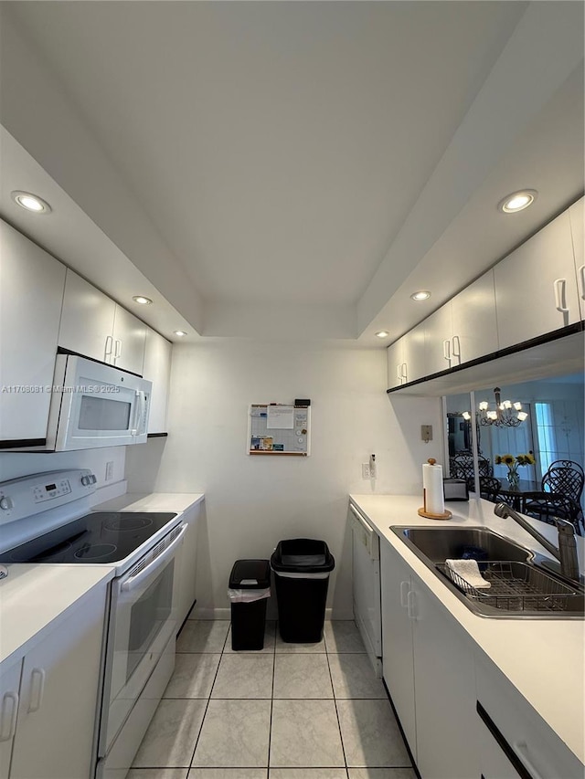 kitchen with sink, light tile patterned flooring, a chandelier, and white appliances