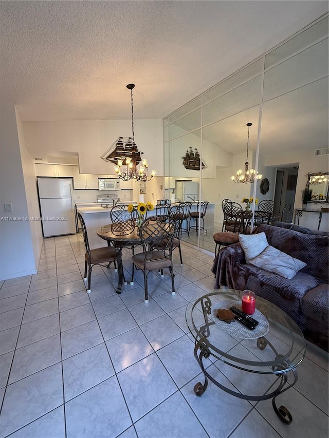 tiled dining space with a textured ceiling and an inviting chandelier