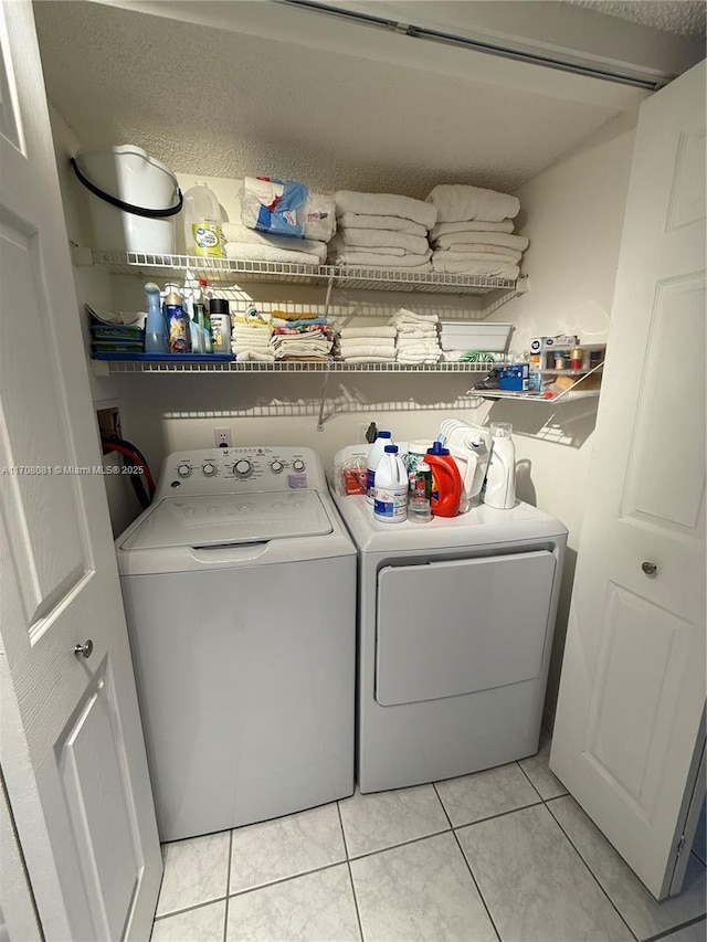 washroom featuring washer and clothes dryer and light tile patterned flooring