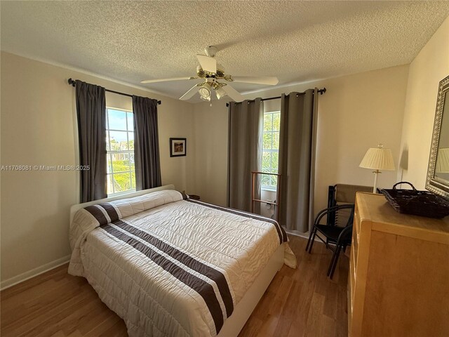 bedroom featuring ceiling fan, light hardwood / wood-style flooring, and a textured ceiling