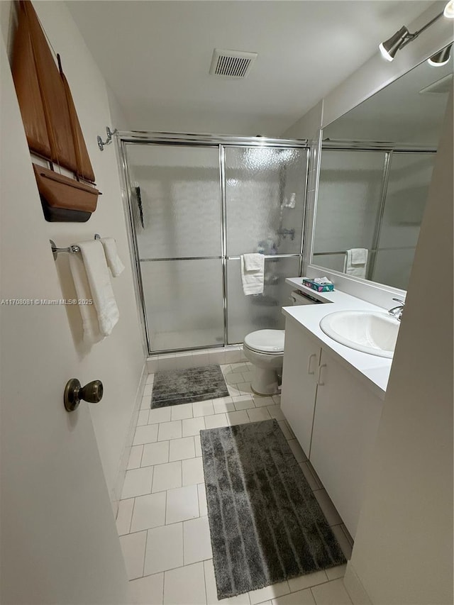 bathroom featuring tile patterned floors, vanity, toilet, and walk in shower