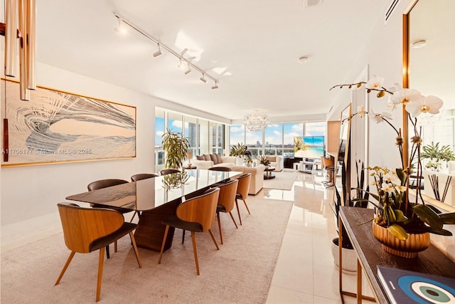 dining room featuring expansive windows, track lighting, and light tile patterned floors