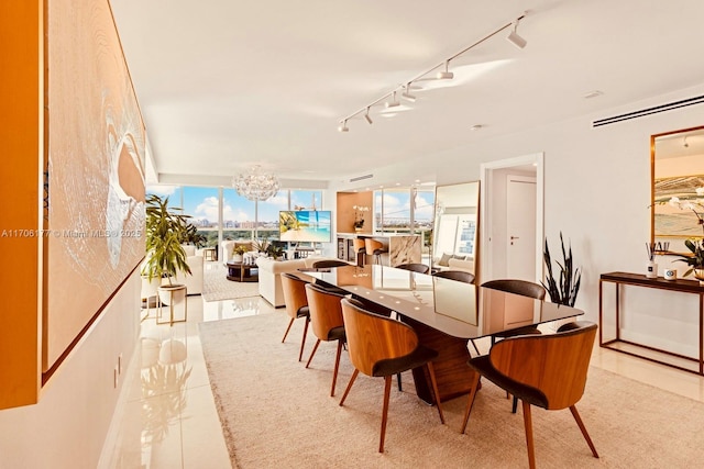 dining area featuring a notable chandelier, track lighting, and light tile patterned floors