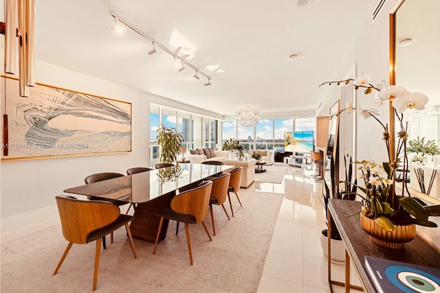 tiled dining area featuring track lighting and a notable chandelier