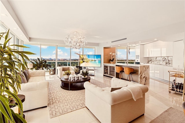 living room featuring a wall of windows, a wealth of natural light, a notable chandelier, and light tile patterned floors